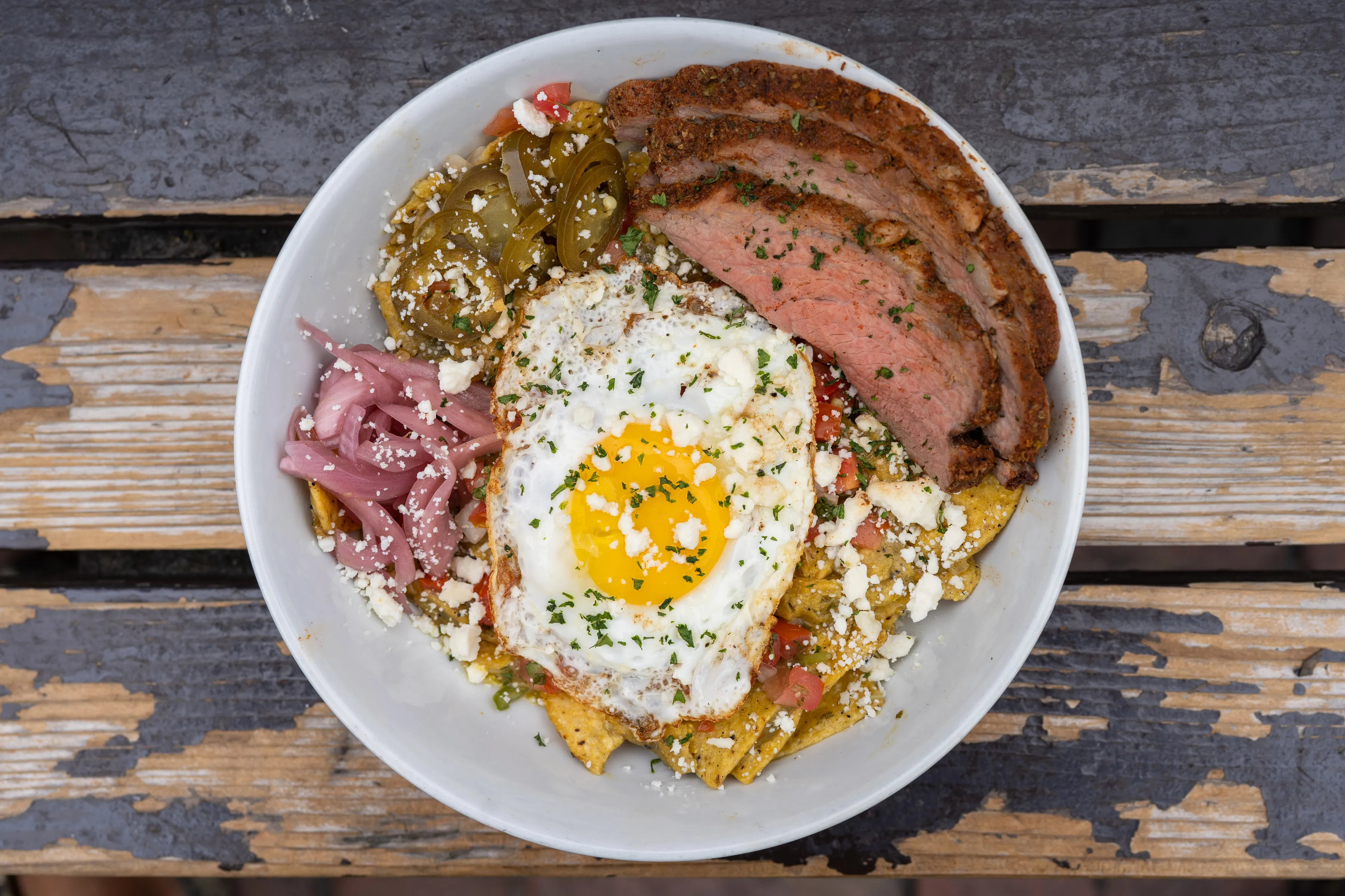 Smoked tri-tip chilaquiles bowl with a fried egg, cotija cheese, pickled onions, and jalapeños at Park 101 brunch