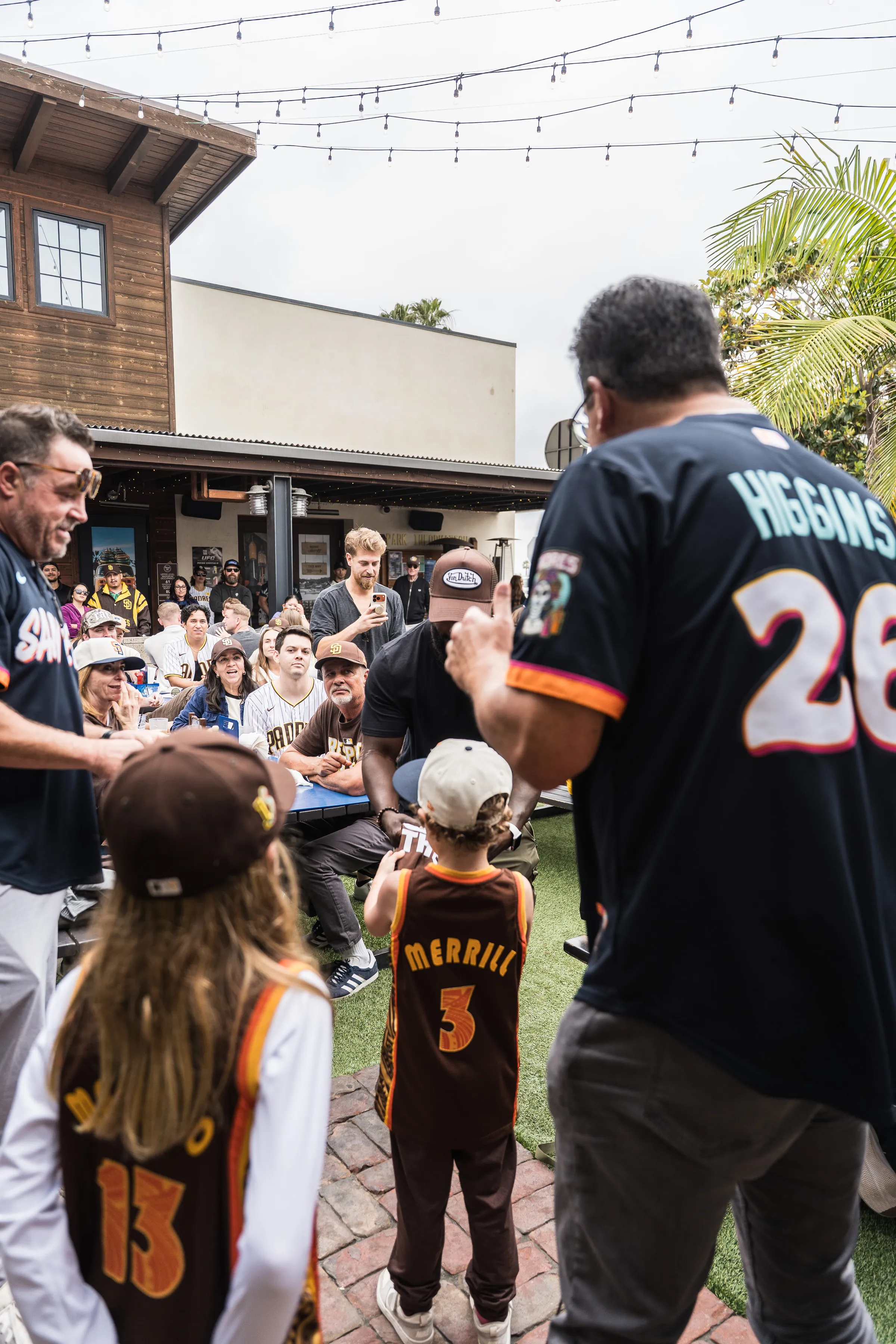 Families and kids in Padres jerseys enjoying game day together at Park 101 Carlsbad