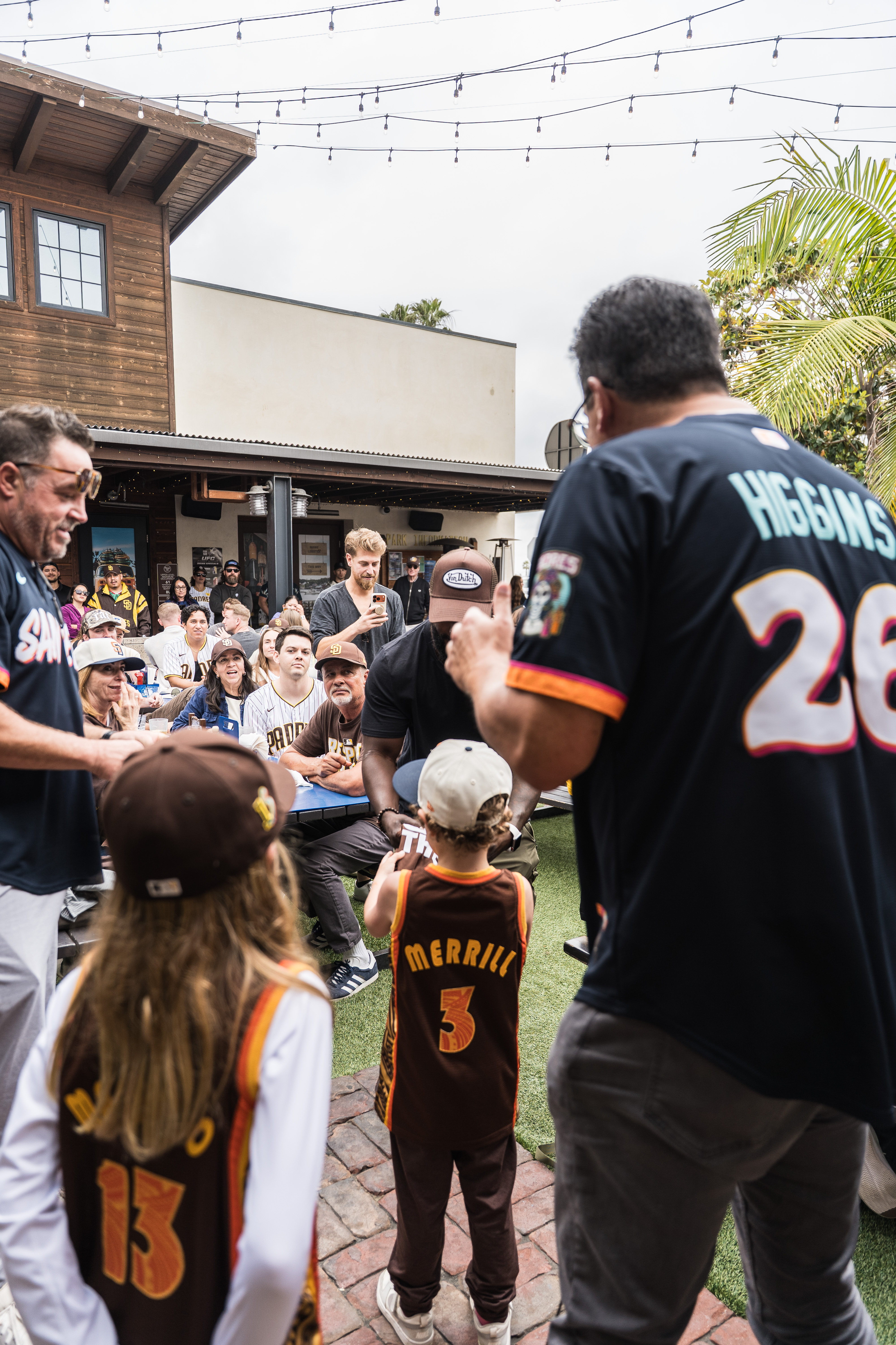 Families and kids in Padres jerseys enjoying game day together at Park 101 Carlsbad