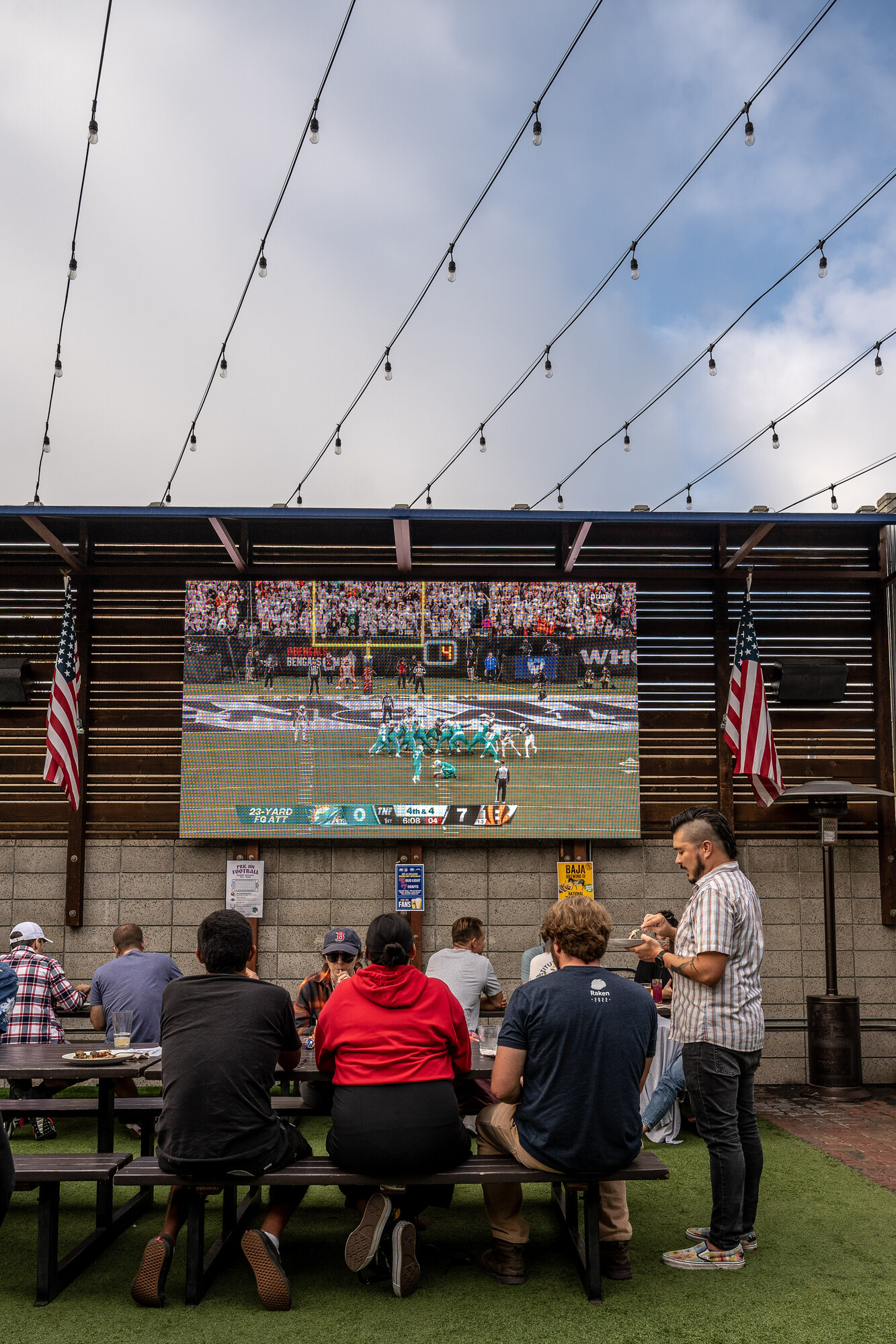 Outdoor sports bar viewing area with multiple screens at Park 101 in Carlsbad