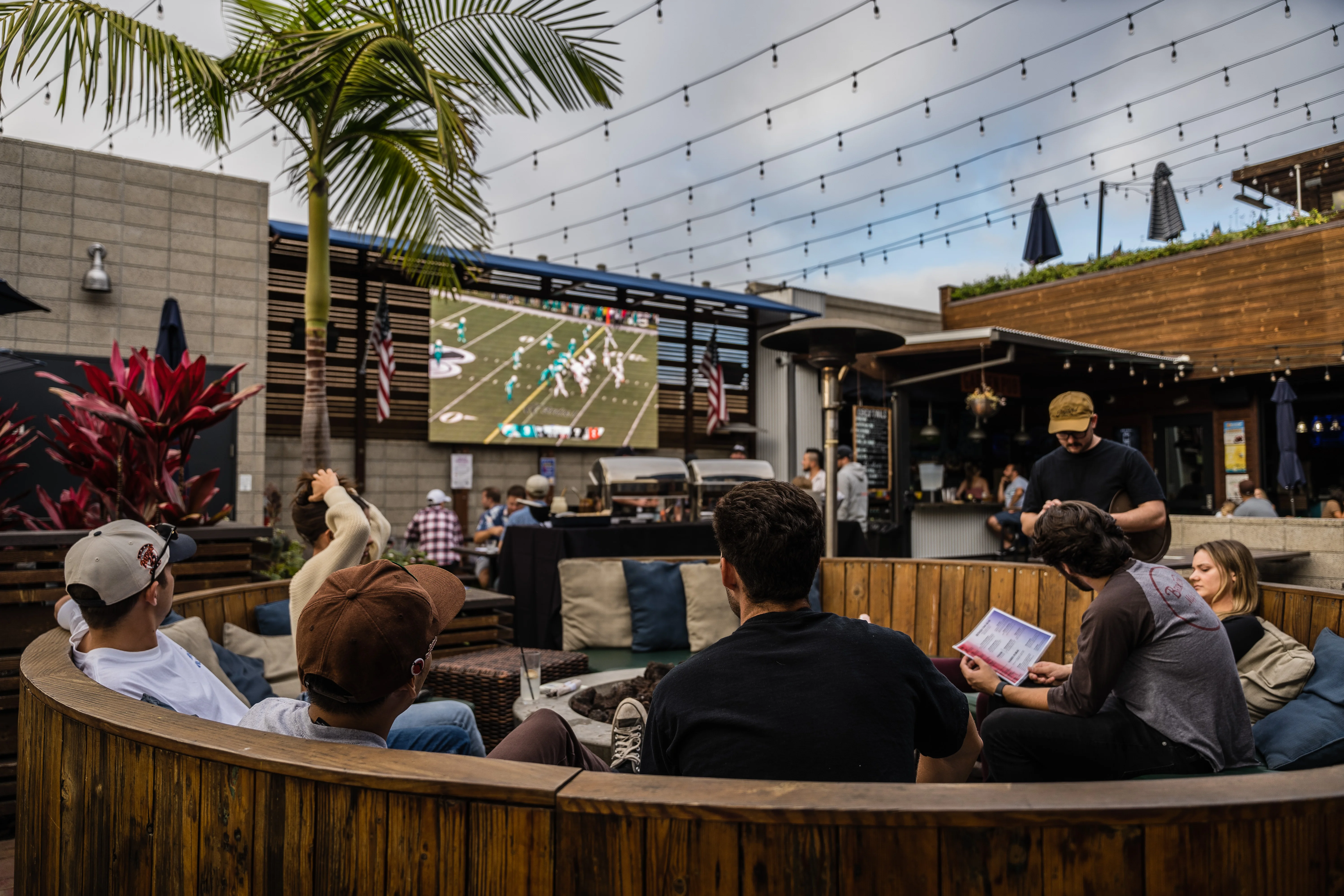 Fans watching football on the outdoor LED screen at Park 101 Carlsbad